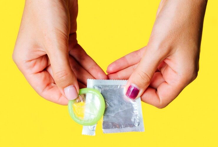 Femme qui ouvre un préservatif