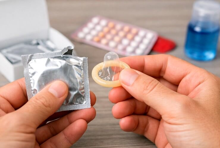 Homme tenant un préservatif